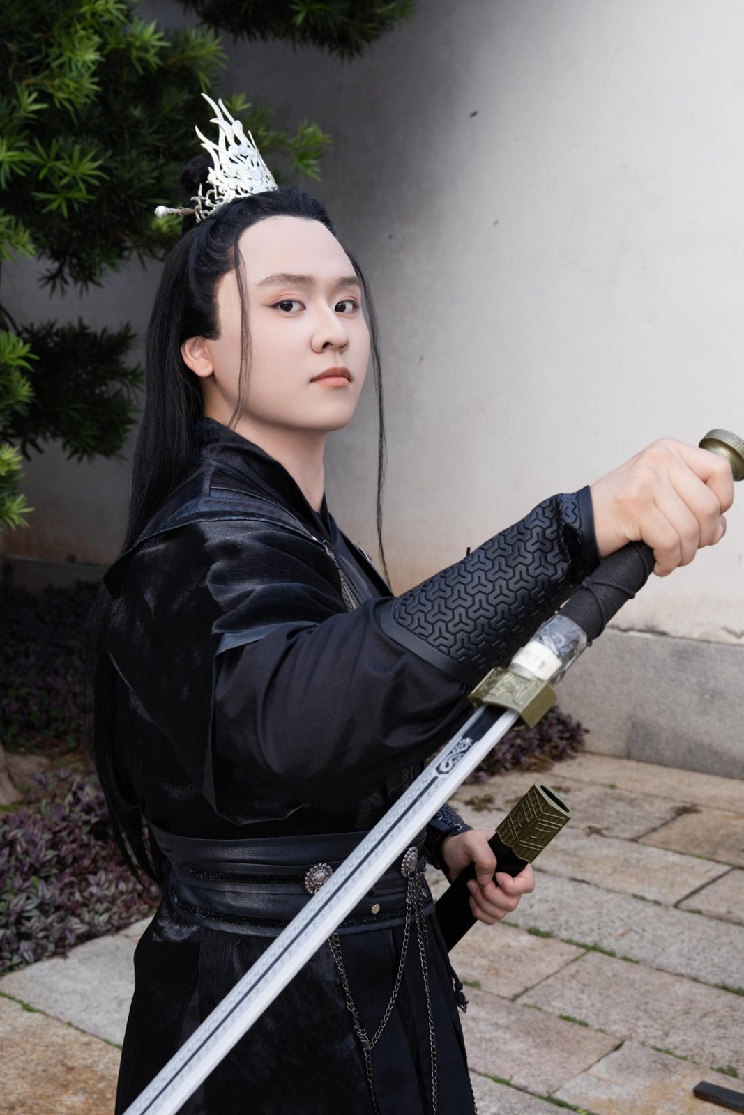 Justin in a black hanfu, drawing a sword